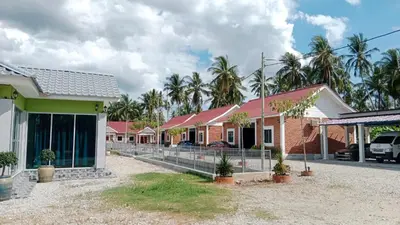 a row of houses with palm trees in the background at As Sufi Villa in Kampung Sungai Air Tawar