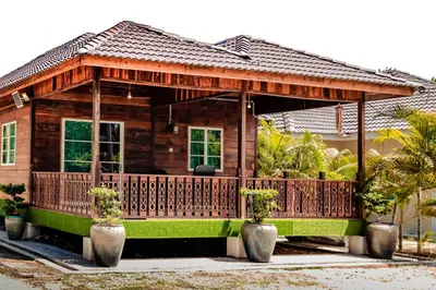 a small wooden house with a wooden deck at As Sufi Villa in Kampung Sungai Air Tawar