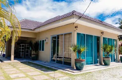 a house with large glass doors and palm trees at As Sufi Villa in Kampung Sungai Air Tawar