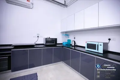 a kitchen with black counter tops and white cabinets at 15BR SwimmingPool Villa Golf View Snooker BBQ in Bayan Lepas