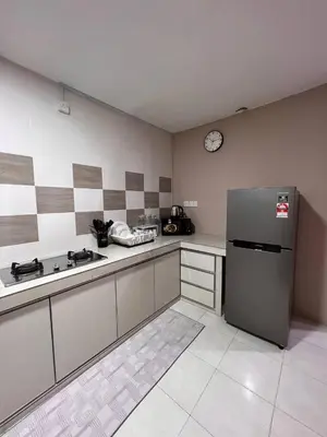a kitchen with a refrigerator and a clock on the wall at Rumah 127 - Homestay Taiping in Simpang
