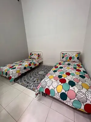 two beds sitting next to each other in a room at Rumah 127 - Homestay Taiping in Simpang