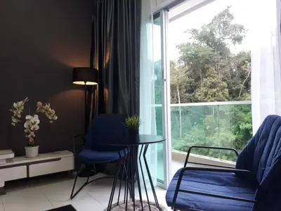a living room with a table and chairs and a large window at Adsyahrizmal Homestay d'Cameron in Tanah Rata