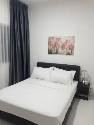 a bedroom with a bed with white sheets and pink flowers at Adsyahrizmal Homestay d'Cameron in Tanah Rata