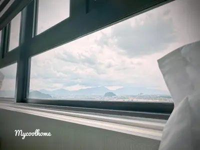 a bedroom window with a view of the mountains at Sunway Onsen Hotsprings with Ipoh City View, Sunway Lost World in Ipoh