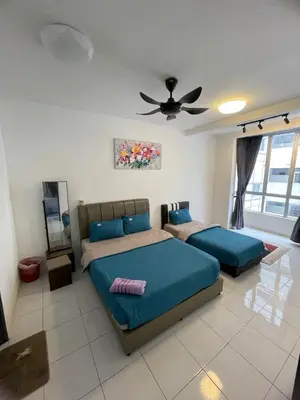 a bedroom with two beds and a ceiling fan at Amy Homestay in Brinchang