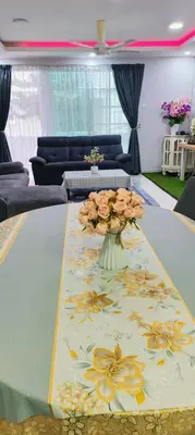 a table with a vase filled with flowers on it at Trails of Kampar Villa Homestay in Kampar