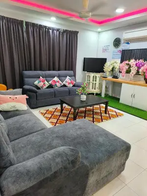 a living room with two couches and a table at Trails of Kampar Villa Homestay in Kampar