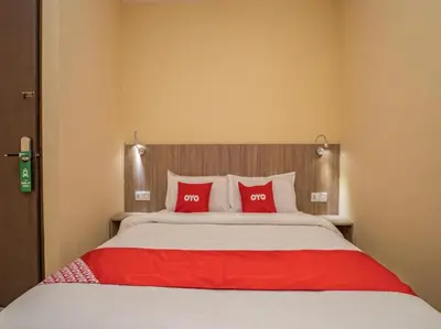 a bedroom with a large bed with two red pillows at Hotel The Island in Pangkor