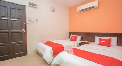 a bedroom with two beds with red and white sheets at Hotel The Island in Pangkor