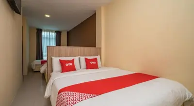 a bedroom with a large bed with red pillows at Hotel The Island in Pangkor