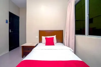 a bedroom with a large bed with a red pillow at Hotel The Island in Pangkor