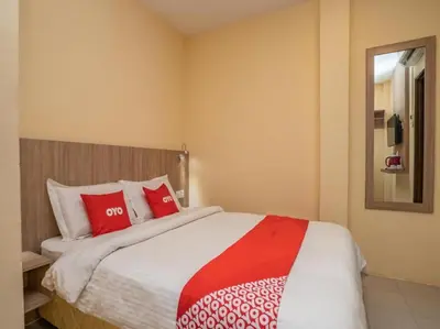 a bedroom with a large bed with red and white pillows at Hotel The Island in Pangkor