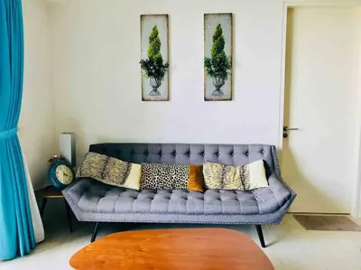 a living room with a blue couch with pillows on it at 5 Stars Seafront Suite By The Sea \u65e5\u843d\u65e0\u654c\u5168\u6d77\u666f 5\u661f \u9152\u5e97\u7b49\u7ea7 in Batu Ferringhi