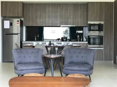 a kitchen with a table and chairs in a kitchen at 5 Stars Seafront Suite By The Sea \u65e5\u843d\u65e0\u654c\u5168\u6d77\u666f 5\u661f \u9152\u5e97\u7b49\u7ea7 in Batu Ferringhi