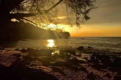 a sunset on the shore of a beach at 5 Stars Seafront Suite By The Sea \u65e5\u843d\u65e0\u654c\u5168\u6d77\u666f 5\u661f \u9152\u5e97\u7b49\u7ea7 in Batu Ferringhi