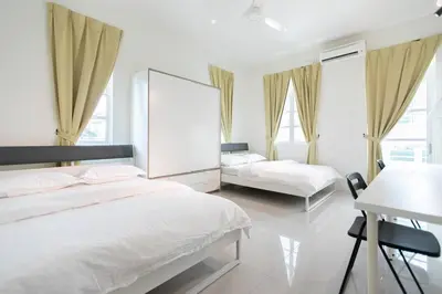 a bedroom with two beds and a desk and windows at Penang Balik Pulau Swimming Pool BBQ KTV Homestay in Balik Pulau