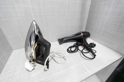 a hair dryer sitting on top of a shelf at Newly Renovated 3Bedroom Vacation Home 6-8pax in Bayan Lepas