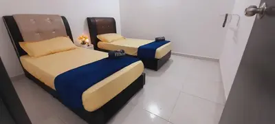 two beds sitting in a room with at Afna Home stay in Kuala Lipis