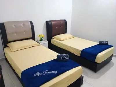 two beds sitting next to each other in a room at Afna Home stay in Kuala Lipis