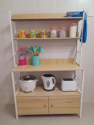a wooden shelf with various kitchen items on it at Afna Home stay in Kuala Lipis