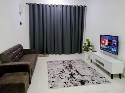 a living room with a couch and a tv at Afna Home stay in Kuala Lipis