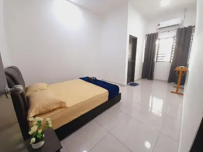 a bedroom with a bed in a white room at Afna Home stay in Kuala Lipis