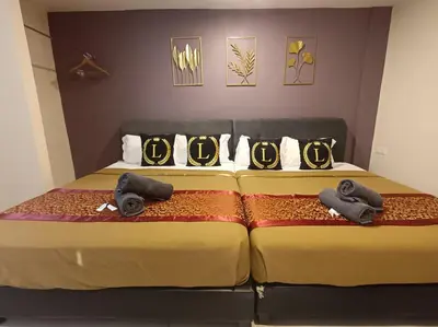 two beds with olympics pillows on top of them at L Ferringhi Hotel in Batu Ferringhi