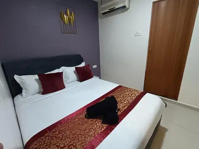 a bedroom with a bed with a black bag on it at L Ferringhi Hotel in Batu Ferringhi