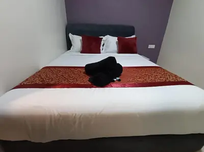 a black backpack sitting on top of a bed at L Ferringhi Hotel in Batu Ferringhi
