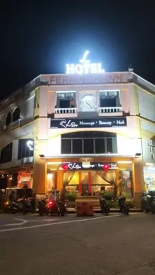 a hotel with motorcycles parked in front of it at night at L Ferringhi Hotel in Batu Ferringhi