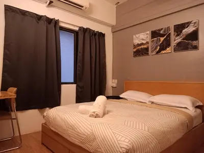 a bedroom with a bed with a towel on it at Sabai Sabai Guesthouse in Bayan Lepas in Bayan Lepas