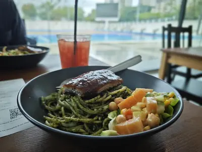 a plate of food with meat and vegetables on a table at Sabai Sabai Guesthouse in Bayan Lepas in Bayan Lepas