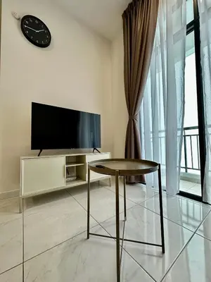 a living room with a tv and a table at 13A5TheSun#BayanLepas#QueensbayMall#CozyHomestay in Bayan Lepas