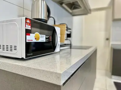 a microwave sitting on a counter in a kitchen at 13A5TheSun#BayanLepas#QueensbayMall#CozyHomestay in Bayan Lepas