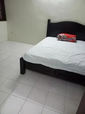 a bedroom with a bed with a red blanket on it at AB Tambun Homestay in Ipoh