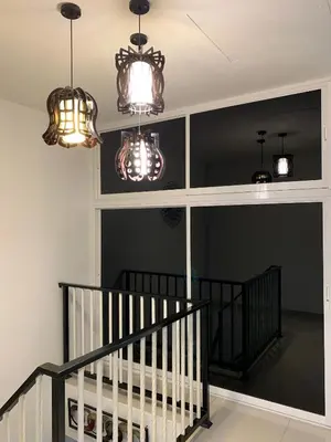 a hallway with three chandeliers and a staircase at Lavender house IPOH in Ipoh