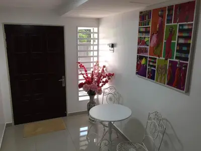 a dining room with a table and a vase with flowers at Lavender house IPOH in Ipoh