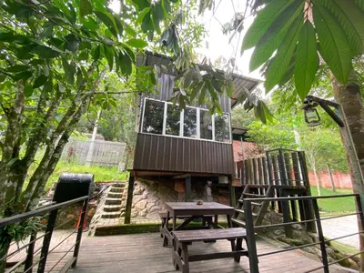 a tree house with two chairs and a bench on a deck at Tingkat Valley in Ipoh
