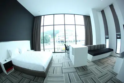a hotel room with a bed and a large window at Beverly Hotel in Taiping
