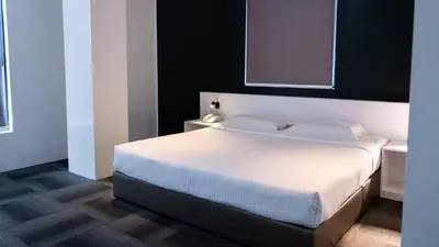 a bedroom with a large white bed in a room at Beverly Hotel in Taiping