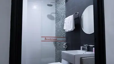 a bathroom with a sink and a toilet and a mirror at Beverly Hotel in Taiping