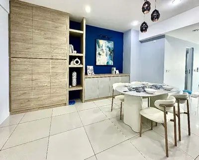 a kitchen with a table and chairs and a blue wall at SUNRISE GURNEY FULLSEAVIEW LUXURY 2ROOM SUITE 8PAX in Kampong Makam