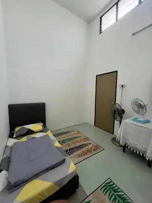 a bedroom with a bed and a table with a fan at Tapak 173 by Sutera Hōmes in Sungai Petani