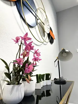 two white vases with pink flowers on a table at PM153 LandedHouse Modern Airport in Bayan Lepas