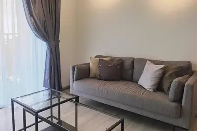 a living room with a couch and a glass table at Emerald Avenue Cozy 3R3B Apartment 716 in Brinchang