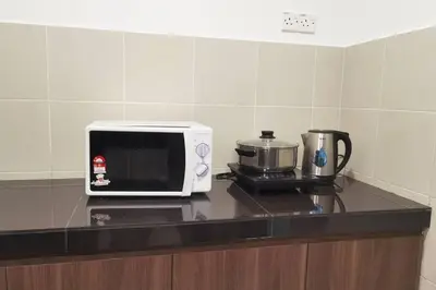 a microwave sitting on a counter next to a coffee maker at Emerald Avenue Cozy 3R3B Apartment 716 in Brinchang