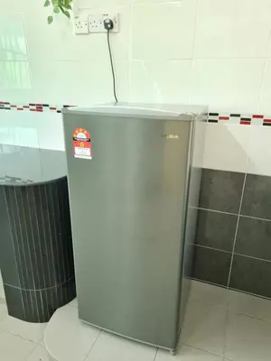 a silver refrigerator in a room with a trash can at Air-home M3 Simpang near Aulong Econsave, 4BR, 10pax, Netflix in Taiping
