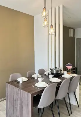 a dining room with a wooden table and chairs at Emerald Avenue Cozy 3R3B Apartment 715 in Brinchang