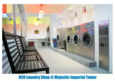 a laundry room with two washing machines and a bench at H2H - Cherry house Majestic in Ipoh